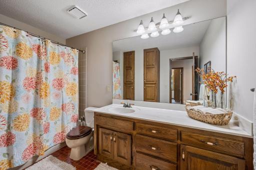 The main floor full bath is spacious and bright with a large vanity and additional wall cabinet for plentiful storage.