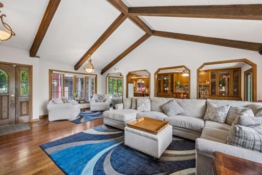 The spacious living room has vaulted ceilings and gleaming solid hardwood floors. It is convenient to the dining room and kitchen for that open concept floor plan while the space still feels defined.