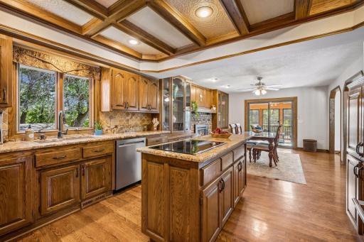 The center island kitchen features rich oak cabinetry, hardwood floors, granite countertops and a lovely stone backsplash.