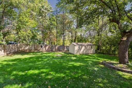 The private side yard area is fenced for privacy and has a large storage shed with double doors for easy access.
