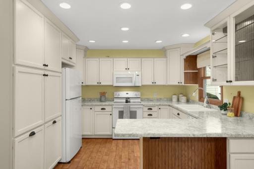 Newer countertops (2021) complement the white cabinetry and hardwood floors. Recessed lighting and plenty of cabinetry complete this spacious Kitchen.