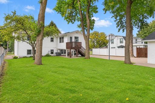 Partially fenced backyard with mature trees and plenty of green space.