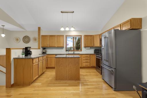 Updated kitchen with stainless steel appliances, granite counters and tile backsplash