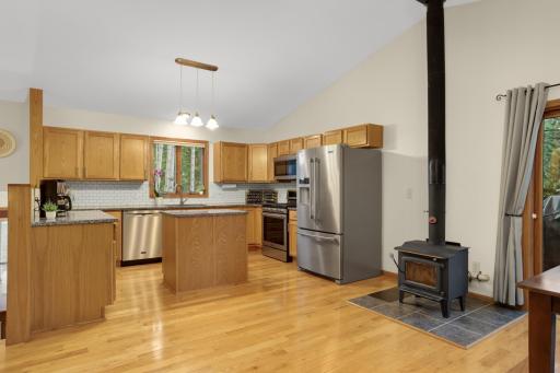Updated kitchen with stainless steel appliances, granite counters and tile backsplash