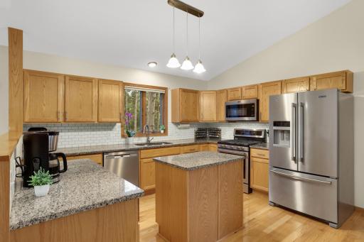 Updated kitchen with stainless steel appliances, granite counters and tile backsplash