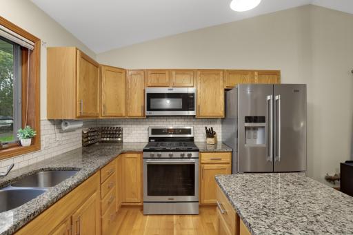 Updated kitchen with stainless steel appliances, granite counters and tile backsplash