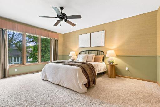 Soft textures and warm lighting give the primary bedroom a calm, comfortable feel.
