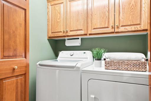 A dedicated laundry room with cabinetry and workspace keeps the practical side of home life organized and out of sight.