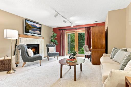 The walkout lower level offers a second comfortable gathering space complete with a fireplace, backyard access, and room for movie nights, games, or guests.