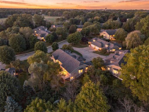 Golden hour brings out the warmth of this home, framed by mature trees and an established neighborhood setting.
