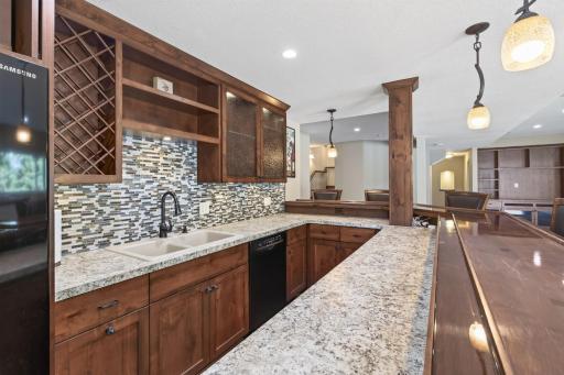 The kitchen includes a full fridge, dishwasher, sink and custom cabinetry