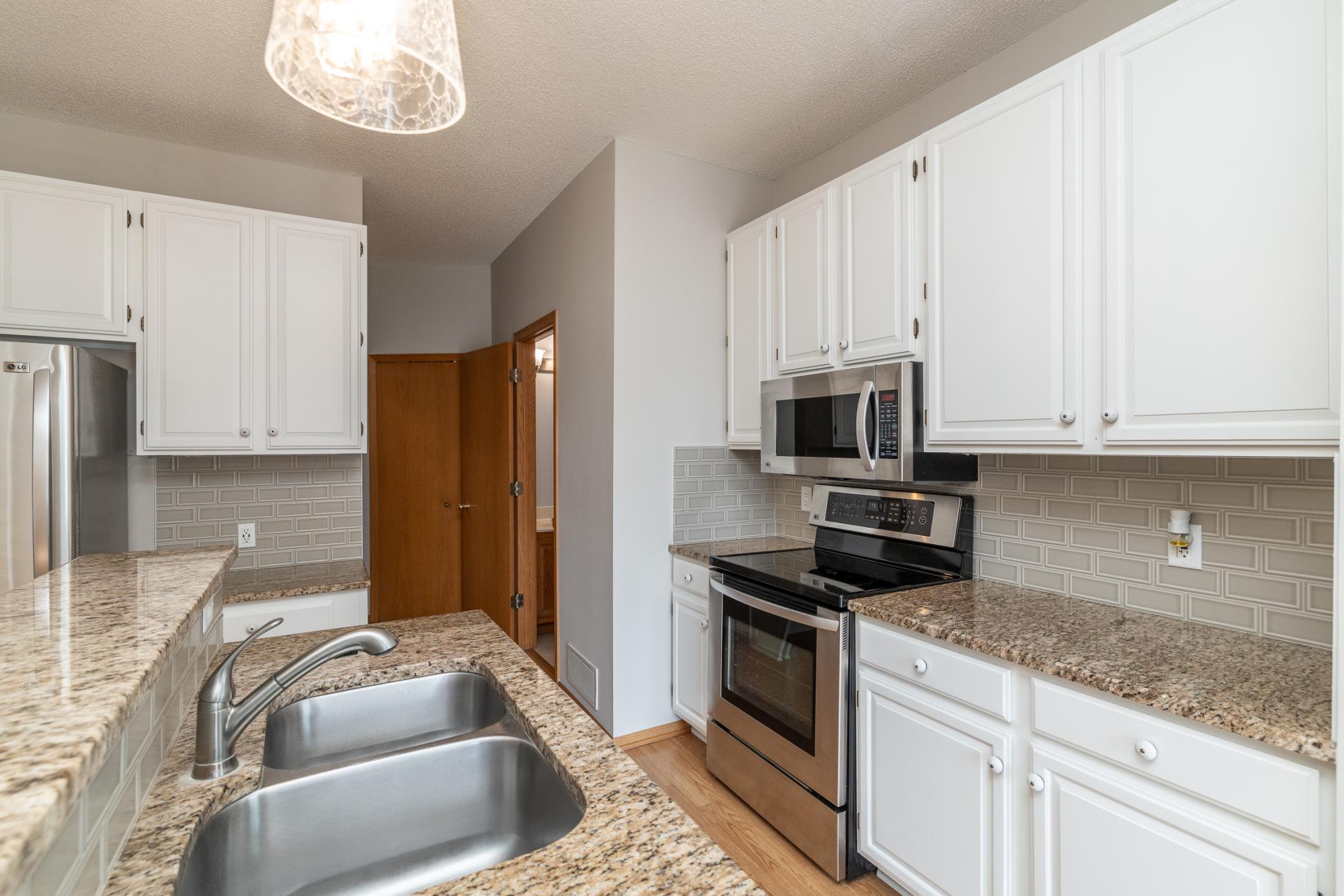 Updated kitchen with granite counters and white cabinets