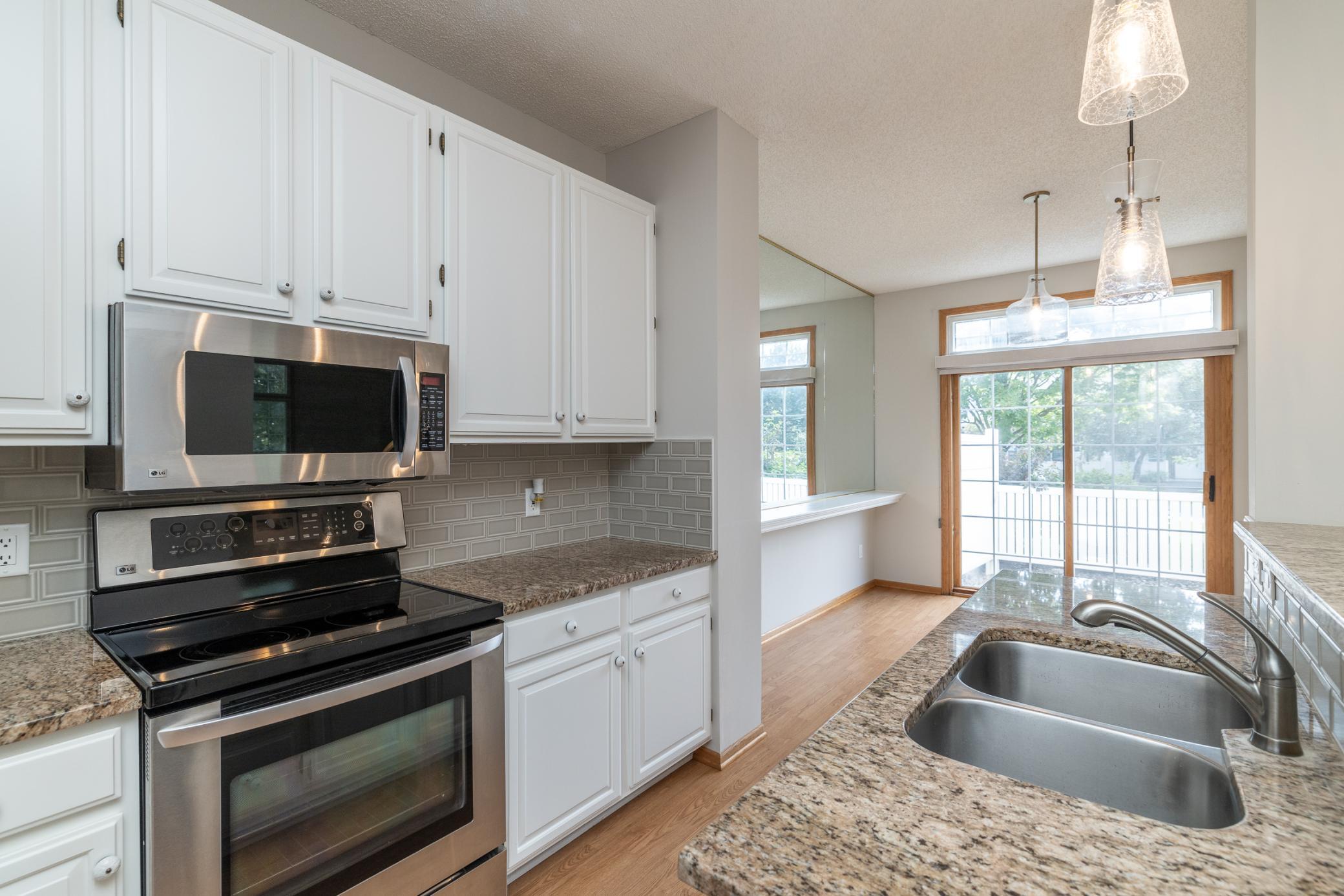 Stainless appliances, granite counters and tile backsplash