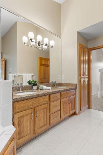 Updated bathroom with quartz countertops, double sinks, fixtures, and hardware, as well as a large linen closet