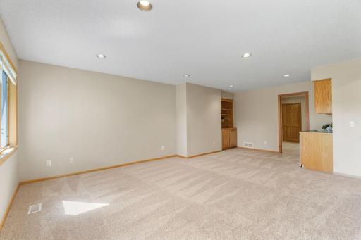 Lower level family room has built in with shelves and cabinets, as well as wet bar