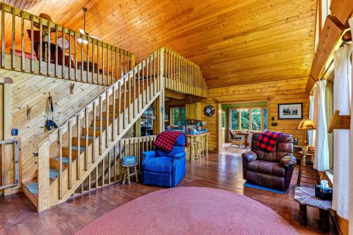 Living room with vaulted ceilings. beautiful staircase leads to the loft