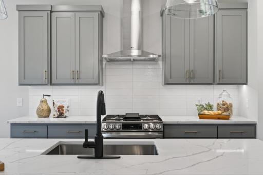 Quartz countertops complimented by timeless tile backsplash.