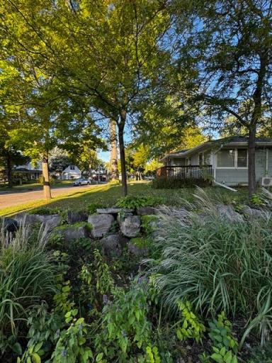 East side home of home has rock wall with variety of perennials to capture rain water. Yard features a lot of perennials and shrubs they could use a gardeners touch to make this place a little piece of paradise.