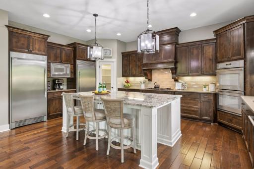Stunning gourmet kitchen offers double ovens, gas range, professional grade appliances with gourgeous quartz & granite counters!