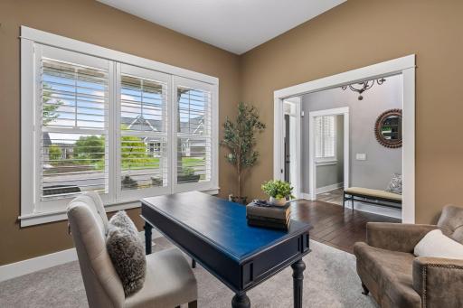 A main level dedicated office with built-ins, plantation shutters and pocket doors for added privacy.