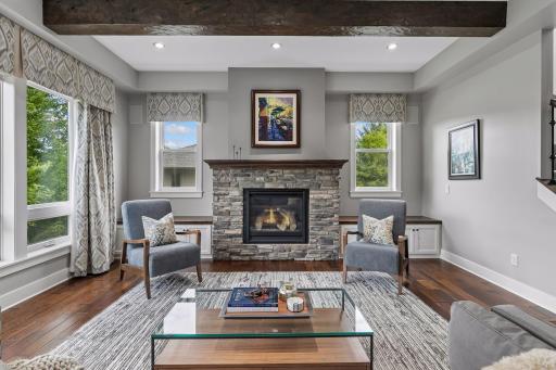 A light filled Great Room with gas fireplace flanked by built-in hardwood seating provides excellent space for entertaining!