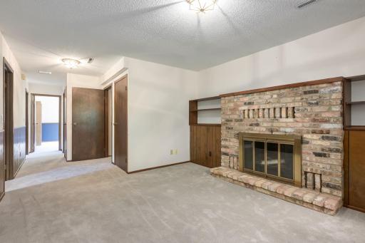 Lower level family room with fireplace looking to lower level bedrooms and bath