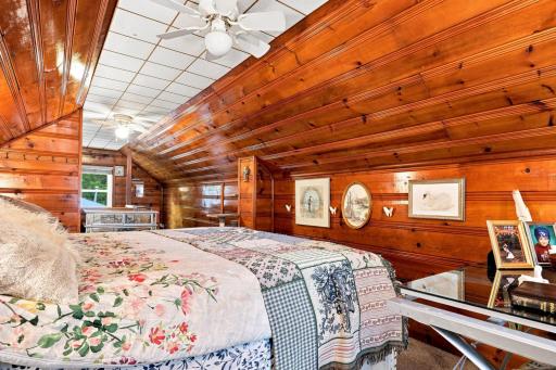 Charming upper-level bedroom retreat featuring warm wood accents, vaulted ceilings, and a cozy cabin-like feel.