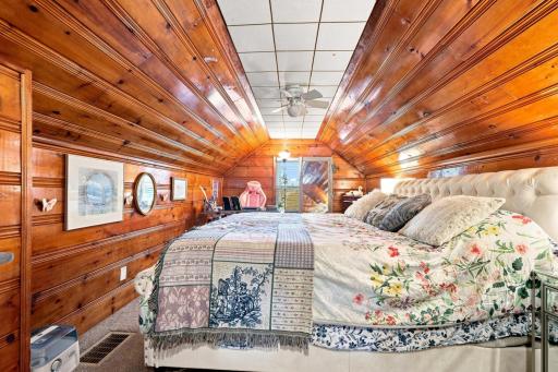 A unique and inviting bedroom with rich pine finishes that create warmth, character, and timeless appeal.