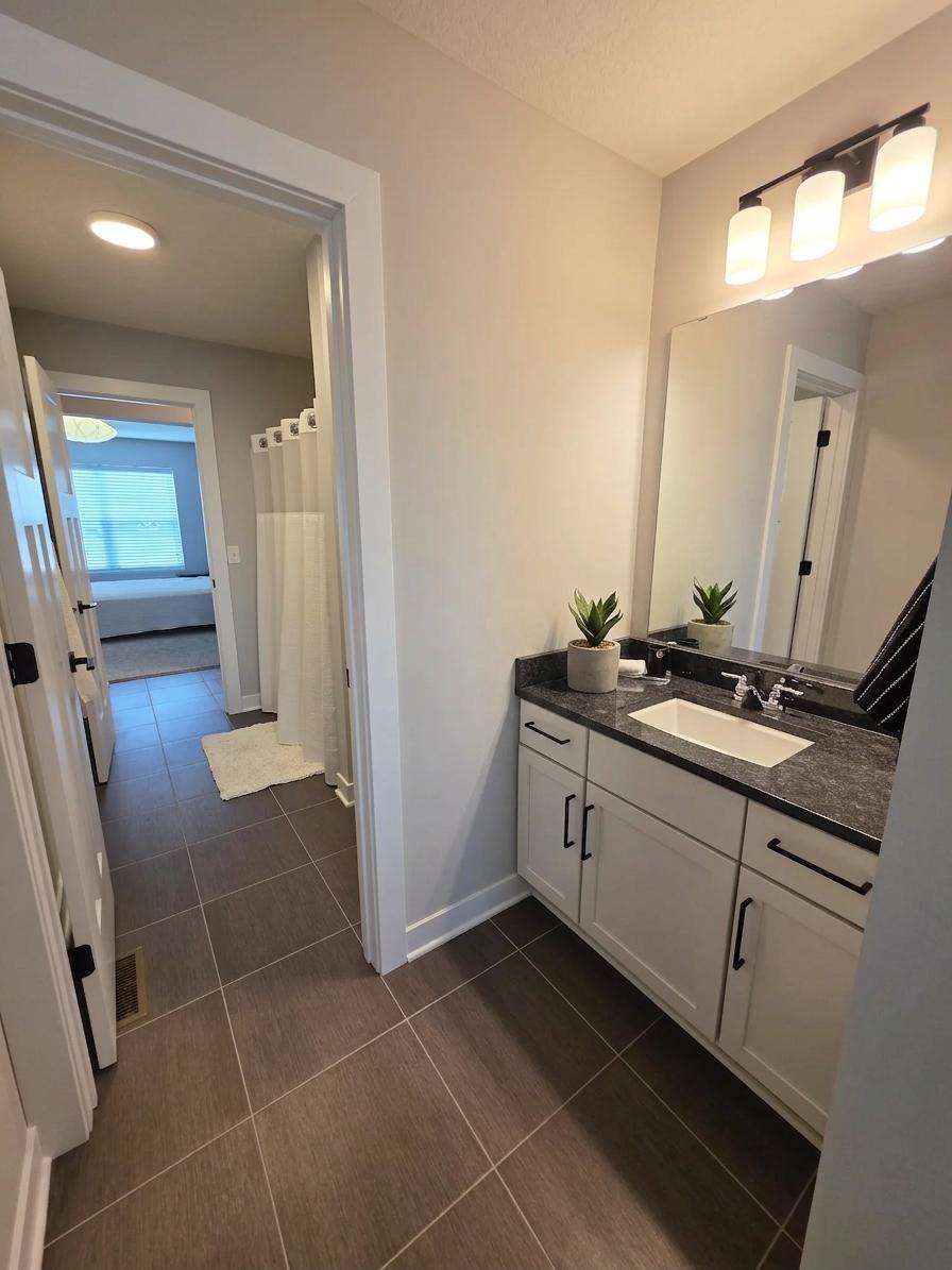 Jack-and-Jill bath features separate private vanity areas for added functionality.