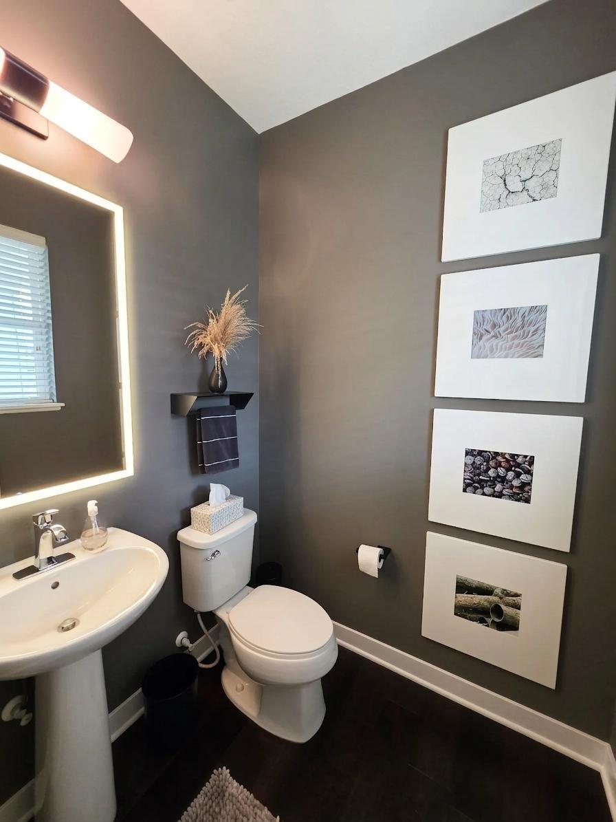 Stylish main-level half bath with dramatic illuminated mirror and modern finishes.