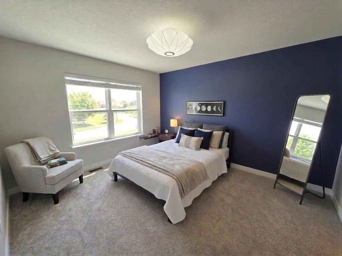 Another spacious upper-level bedroom with large window and contemporary finishes.