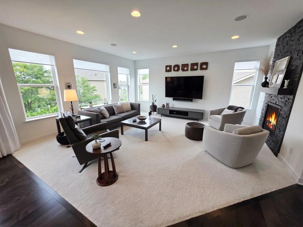 Light-filled family room is anchored by a dramatic floor-to-ceiling stacked-stone fireplace.