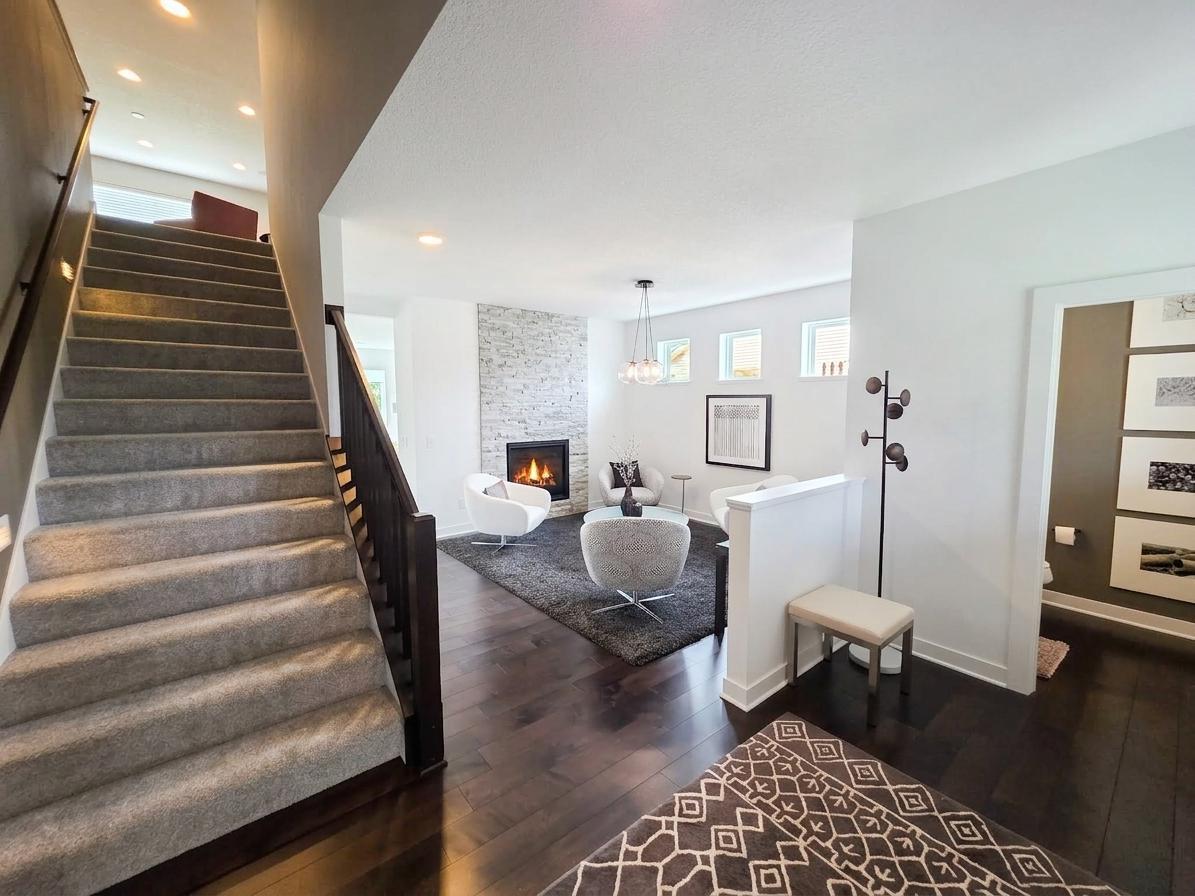 Open main-level layout combines rich hardwood floors, wide stairway and inviting sightlines into the fireplace lounge.
