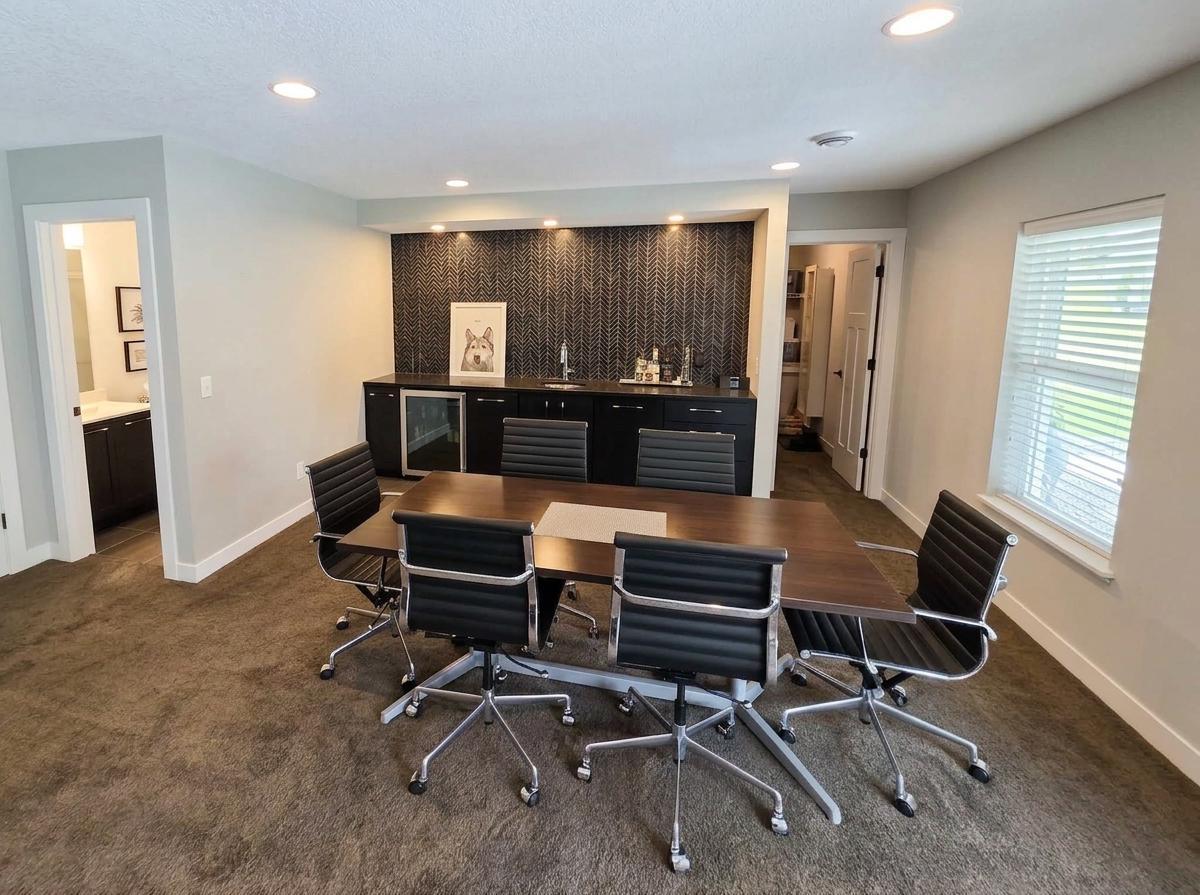 Lower-level wet bar features extensive cabinetry, beverage refrigerator and dramatic backsplash.