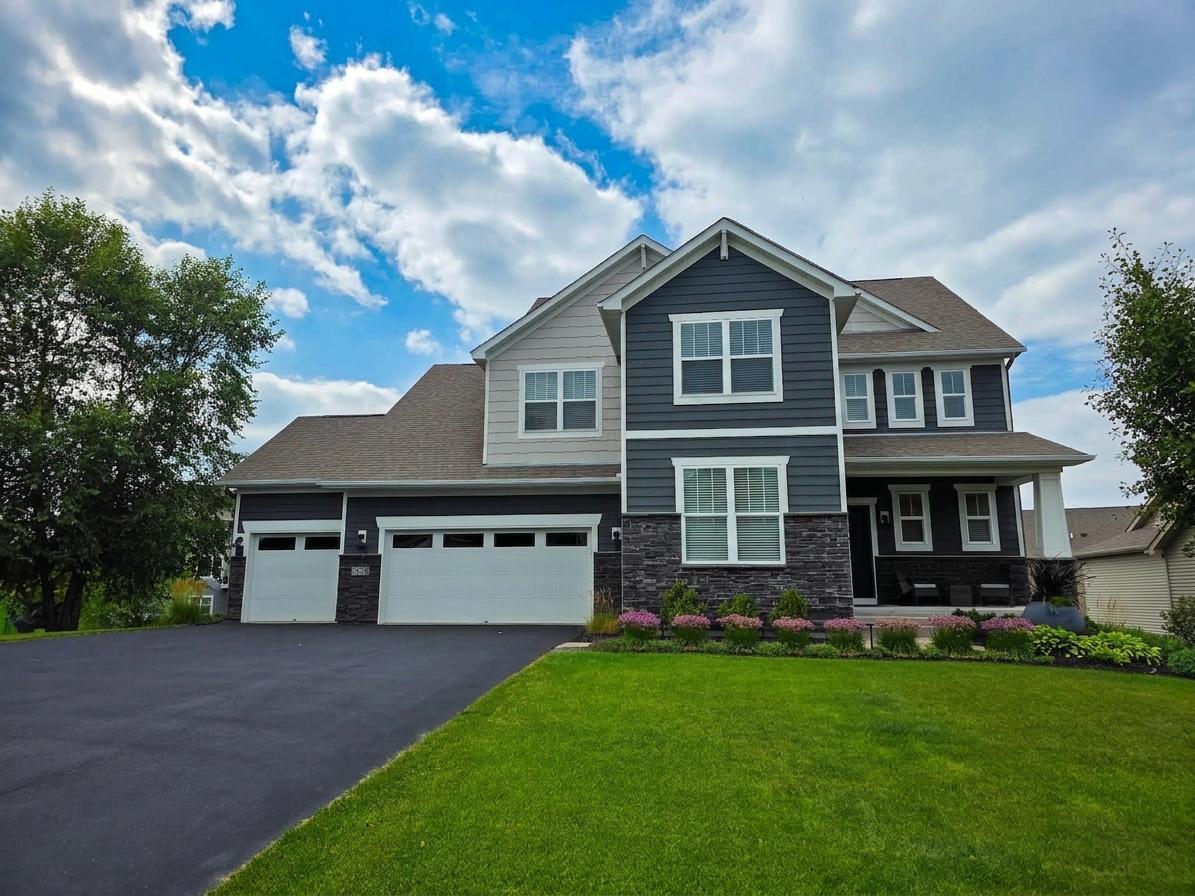 Welcome to 1305 Interlachen Drive! mpressive front elevation with stone detailing, manicured landscaping and a rare four-stall attached garage.