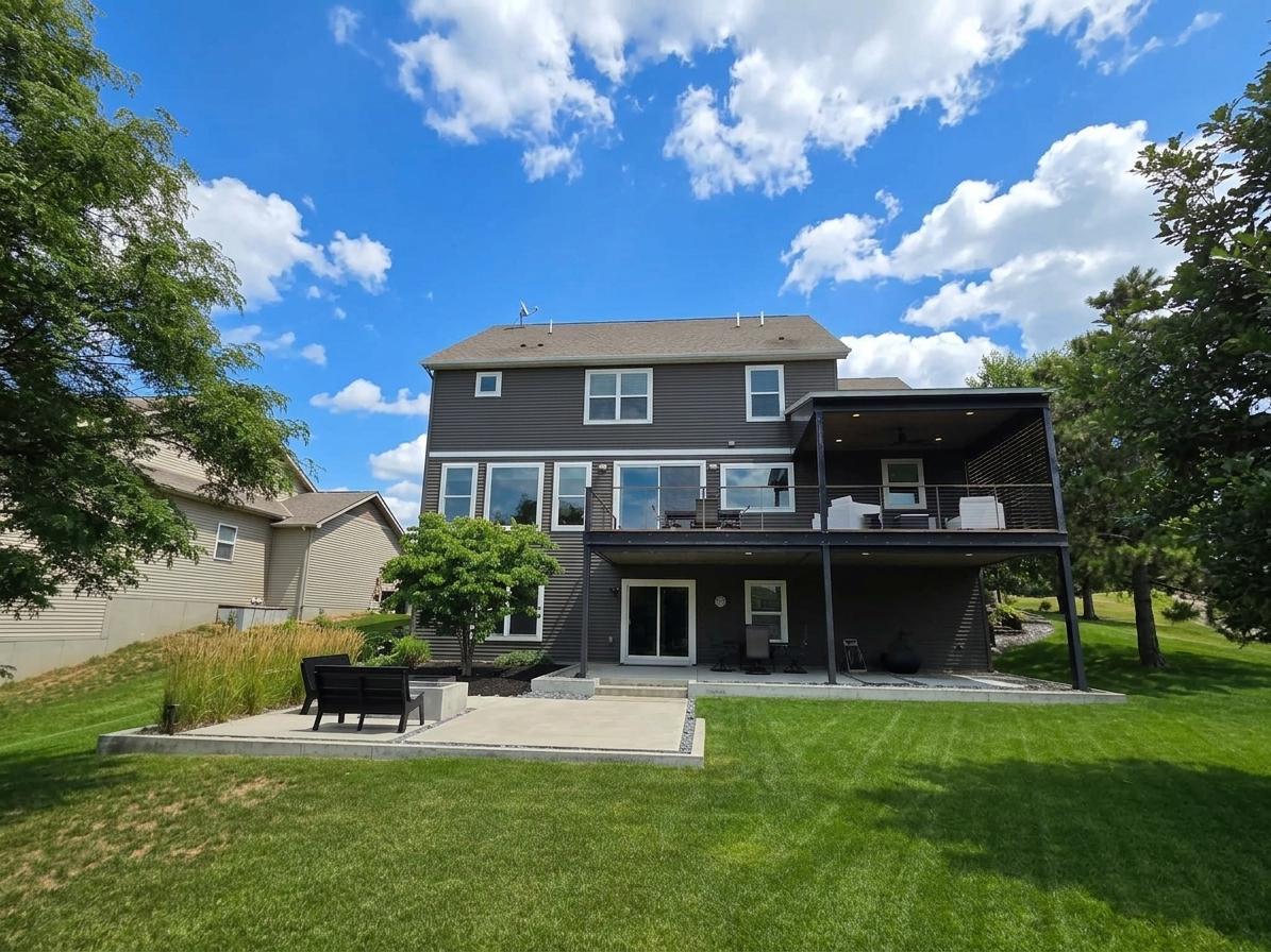 Rear elevation highlights the home's exceptional outdoor design with elevated deck, covered patio and firepit terrace.
