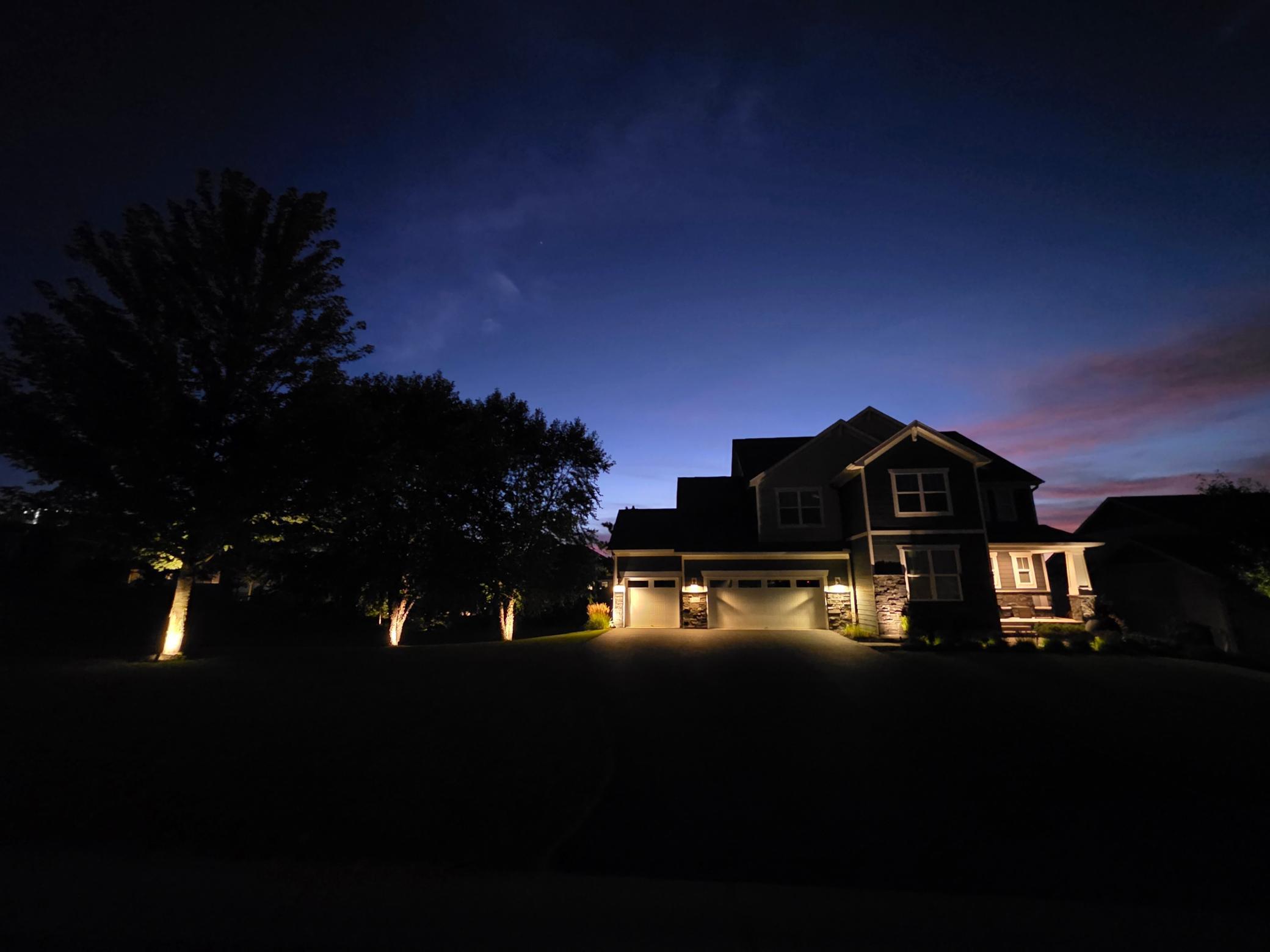 Twilight curb appeal at 1305 Interlachen Drive, highlighted by architectural and landscape lighting.