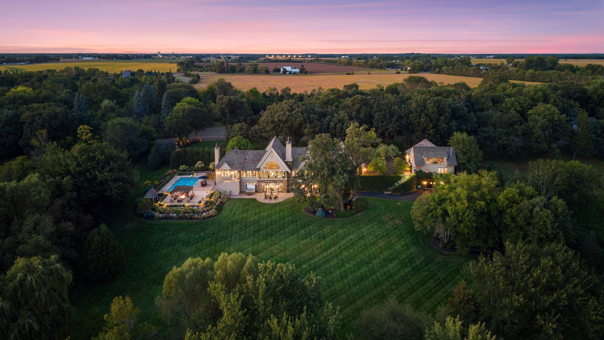 Meticulously maintained landscaping surrounds the residence with mature plantings and lush lawn.