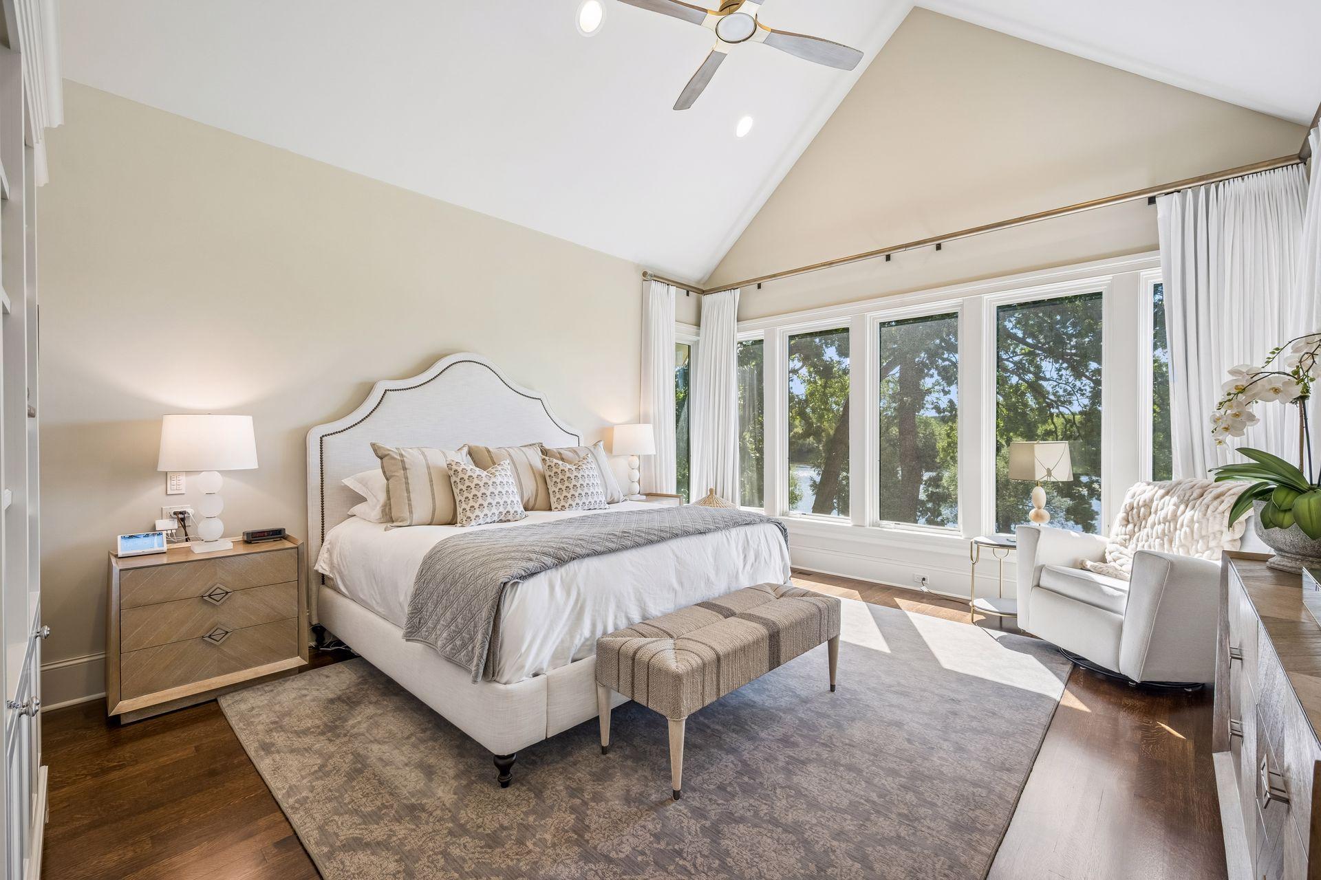 The main-level primary suite offers a private retreat with vaulted ceilings and breathtaking views across the grounds toward the Mississippi River.