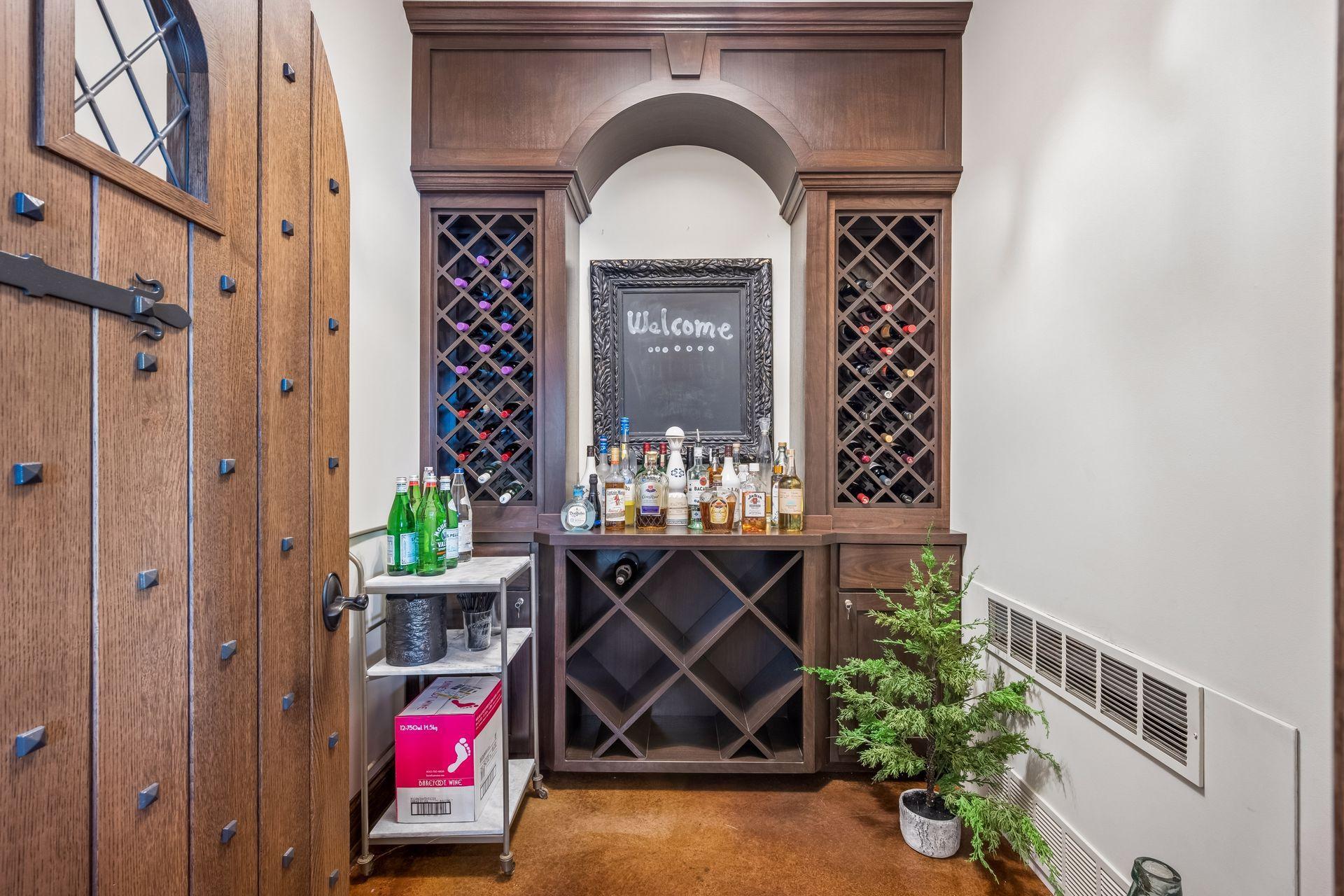An arched doorway introduces the dedicated wine room, complete with built-in wine racks and climate-controlled settings designed for a thoughtfully curated collection.