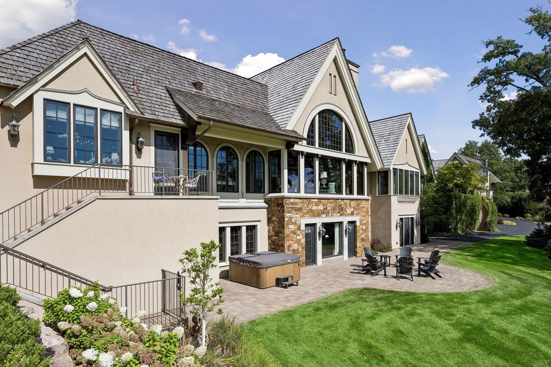 An expansive outdoor gathering space seamlessly connects the pool, patio, manicured grounds, and riverfront setting.