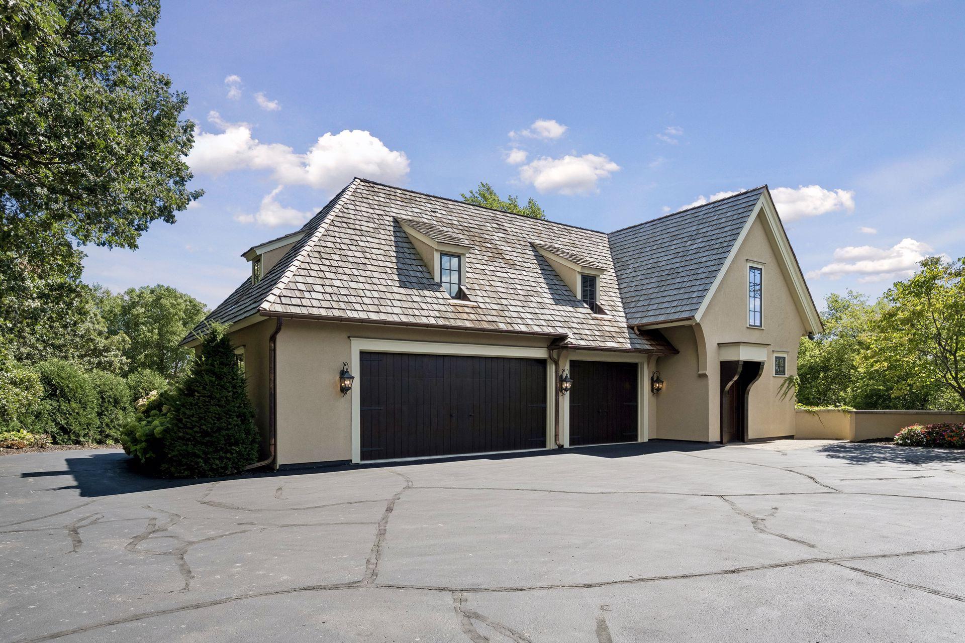 The detached garage offers an extraordinary amount of space with soaring ceilings, abundant natural light, epoxy flooring, extensive cabinetry, and dedicated workshop space.