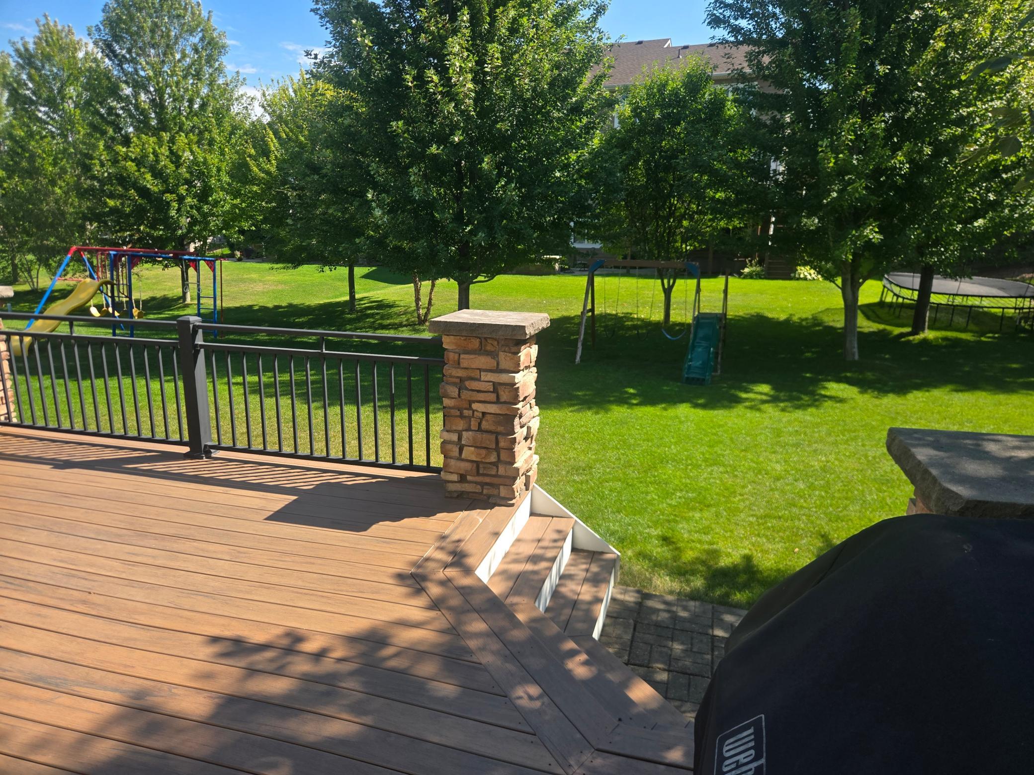 Composite deck with a lush green backyard