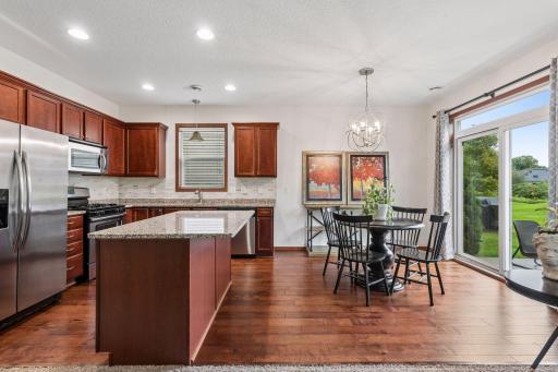 The kitchen boasts gorgeous hardwood flooring, granite counters, stainless steel appliances, and a large center island perfect for gathering with family and friends.