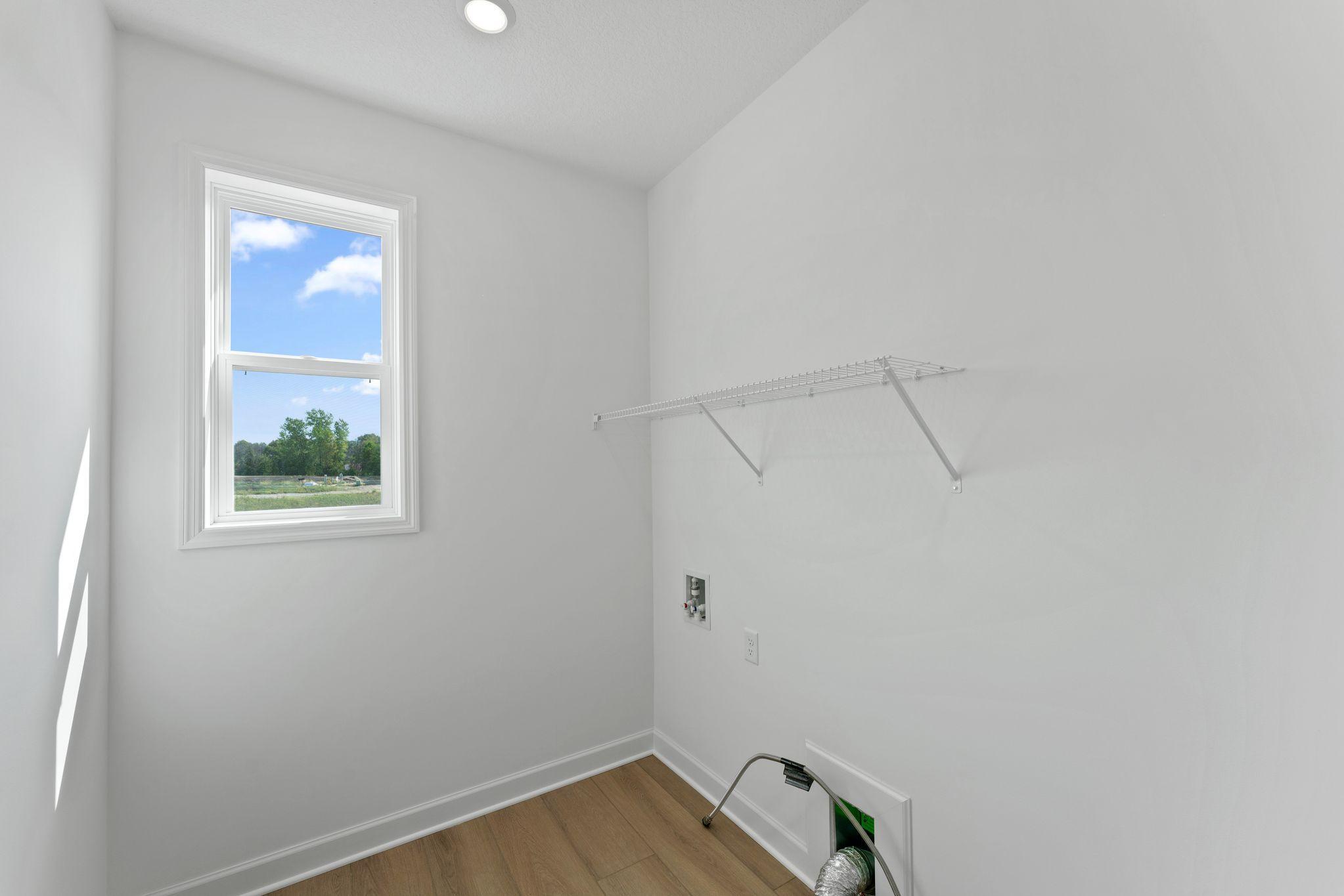 The spacious laundry room features a rinse sink and plenty of space for a new washer and dryer.