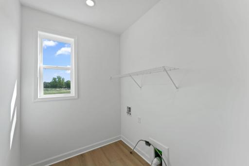 The spacious laundry room features a rinse sink and plenty of space for a new washer and dryer.