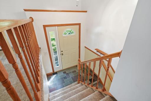 Step inside to a split-level foyer with warm wood railings and easy access to both levels of the home.