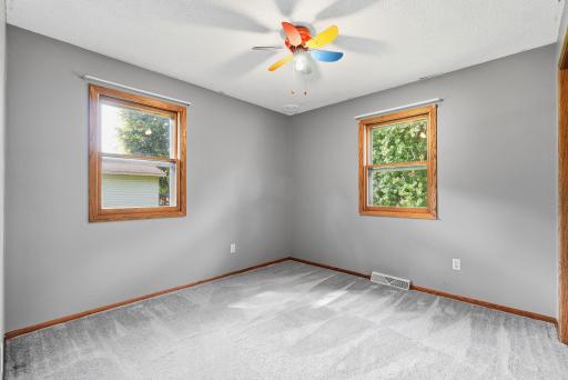 Second upper level bedroom with dual windows and soft neutral finishes.