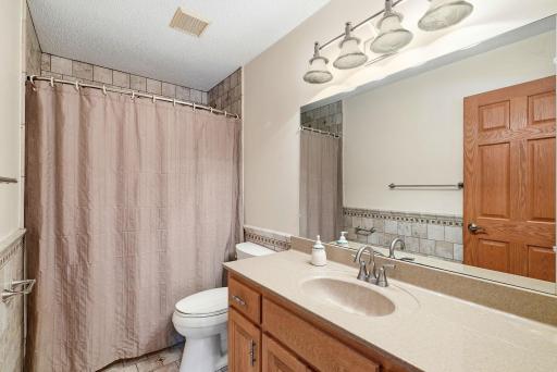The full bathroom features a tub/shower combination, tiled accents and a spacious vanity.