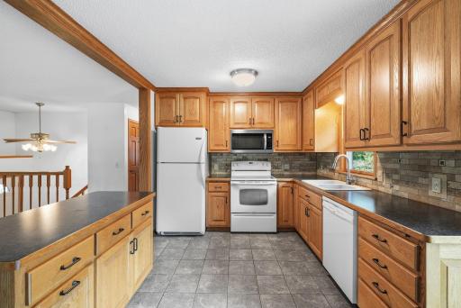 A closer look highlighting the kitchen’s extensive cabinetry, tiled flooring and backsplash.
